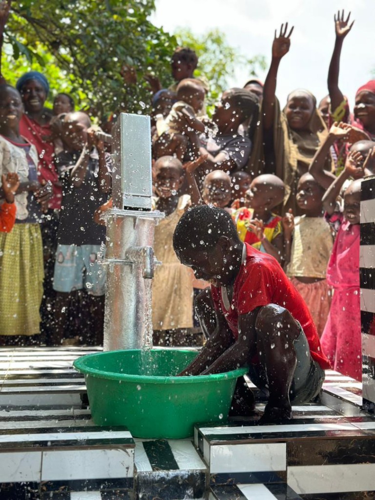 Children using a new BINNAEM water well in Uganda